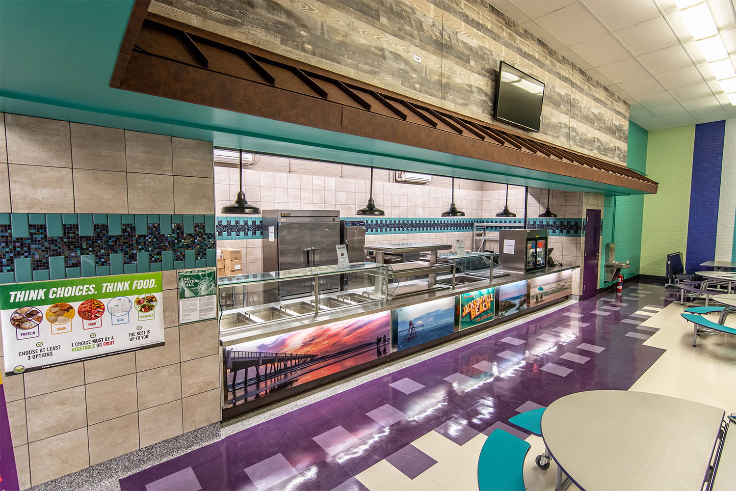 Serving line in student cafeteria with beachy posters and graphics